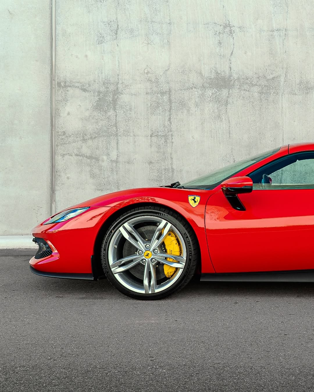 Glossy ceramic-coated car parked against a white wall.