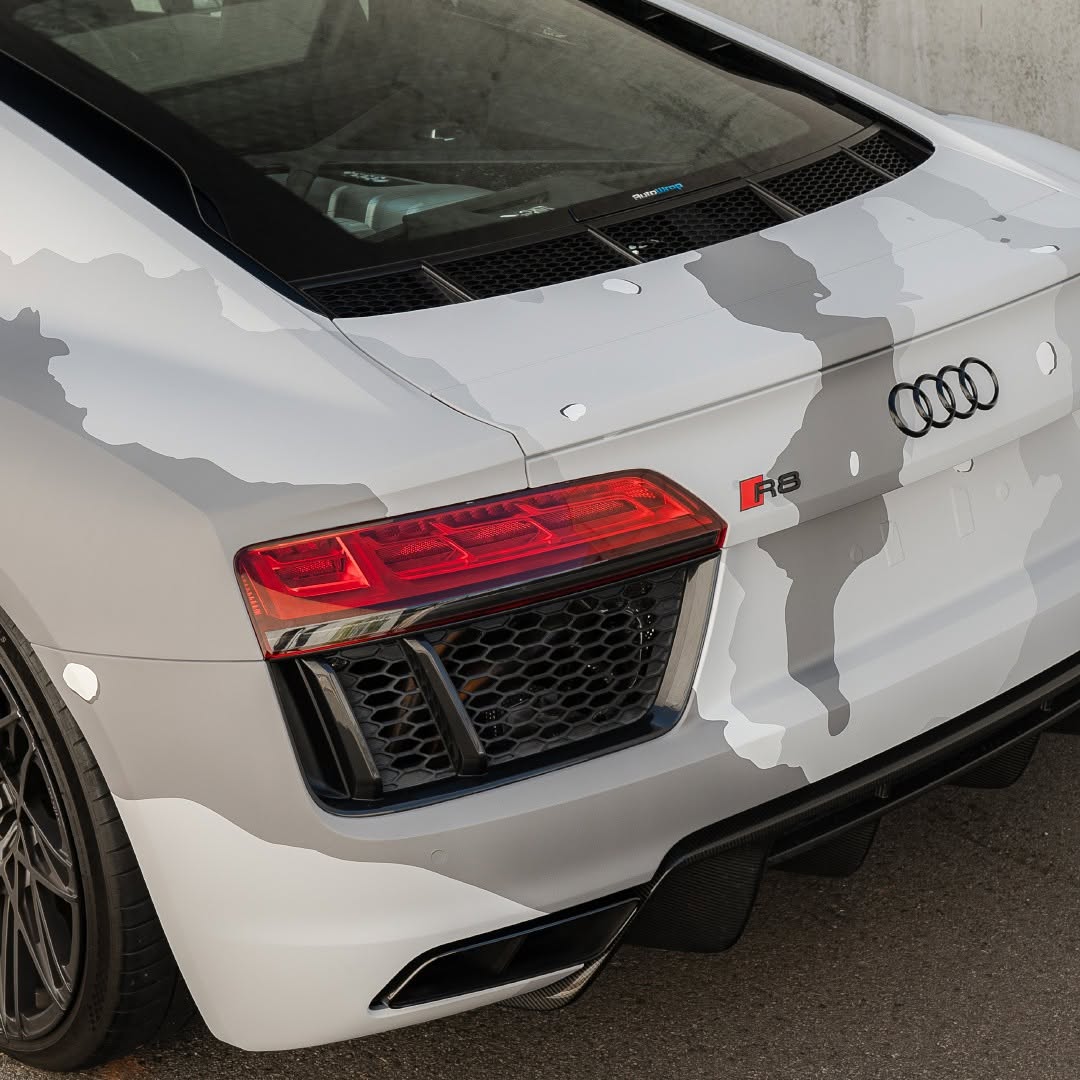 Audi R8 in a custom printed urban-camo vinyl wrap, rear detail.